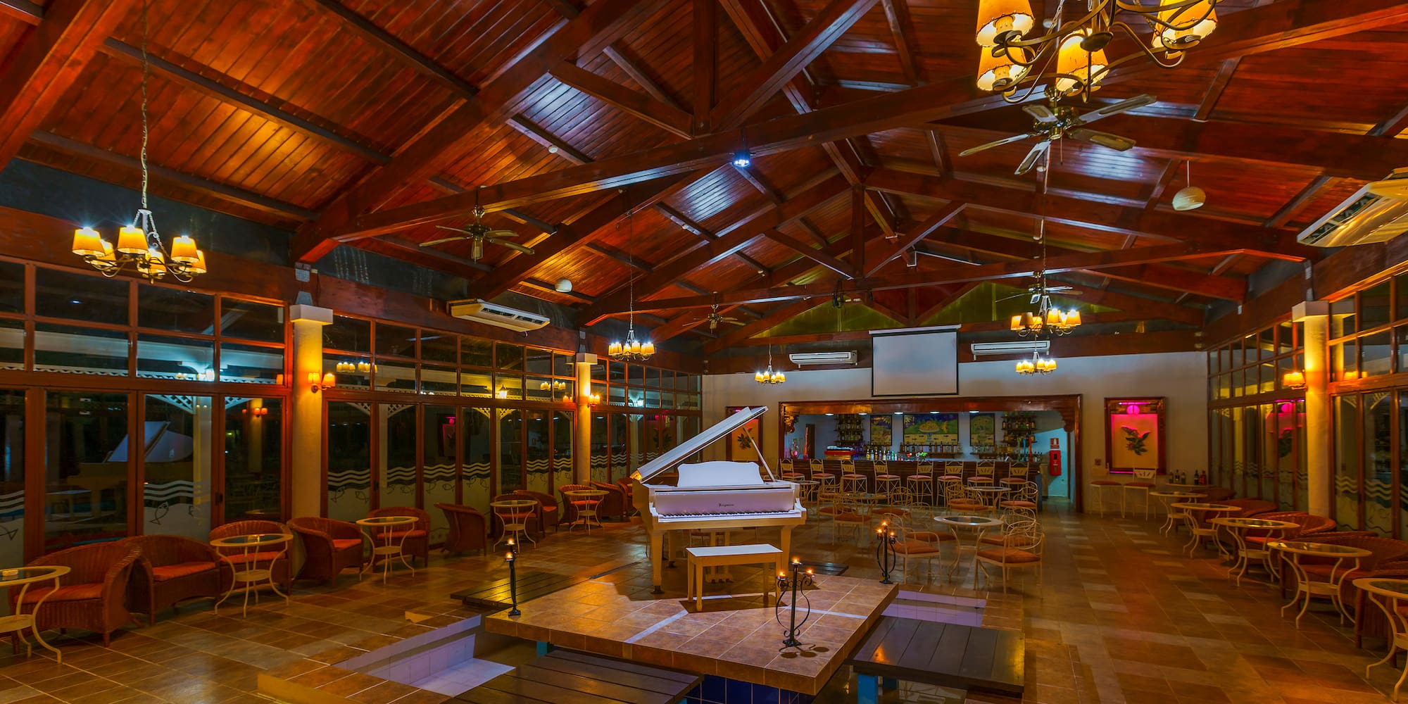 a room with a piano and tables and chairs