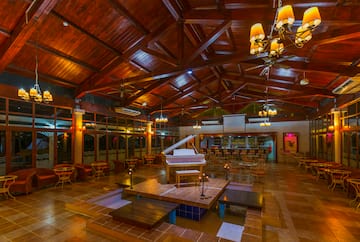 a room with a piano and tables and chairs