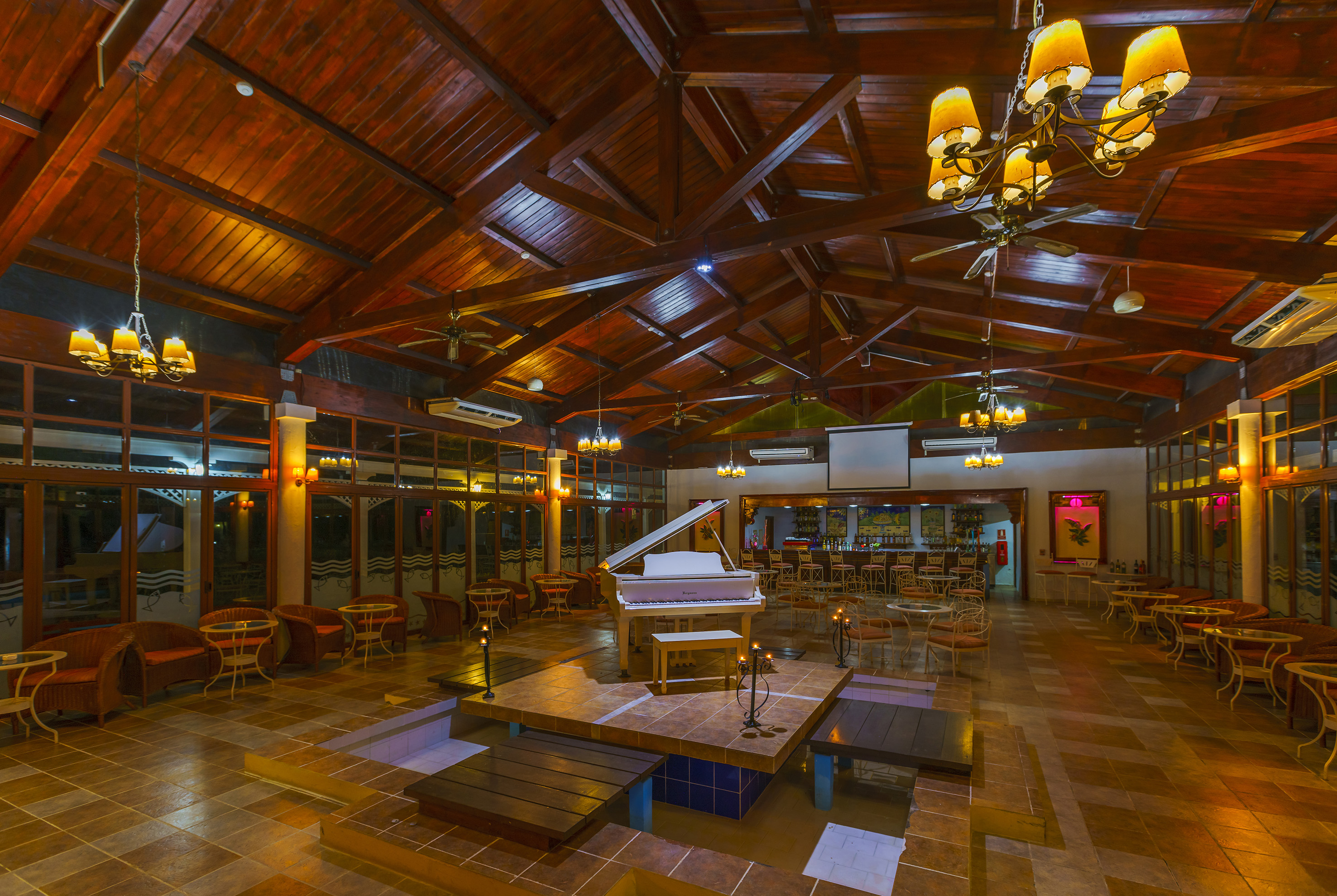 a room with a piano and tables and chairs