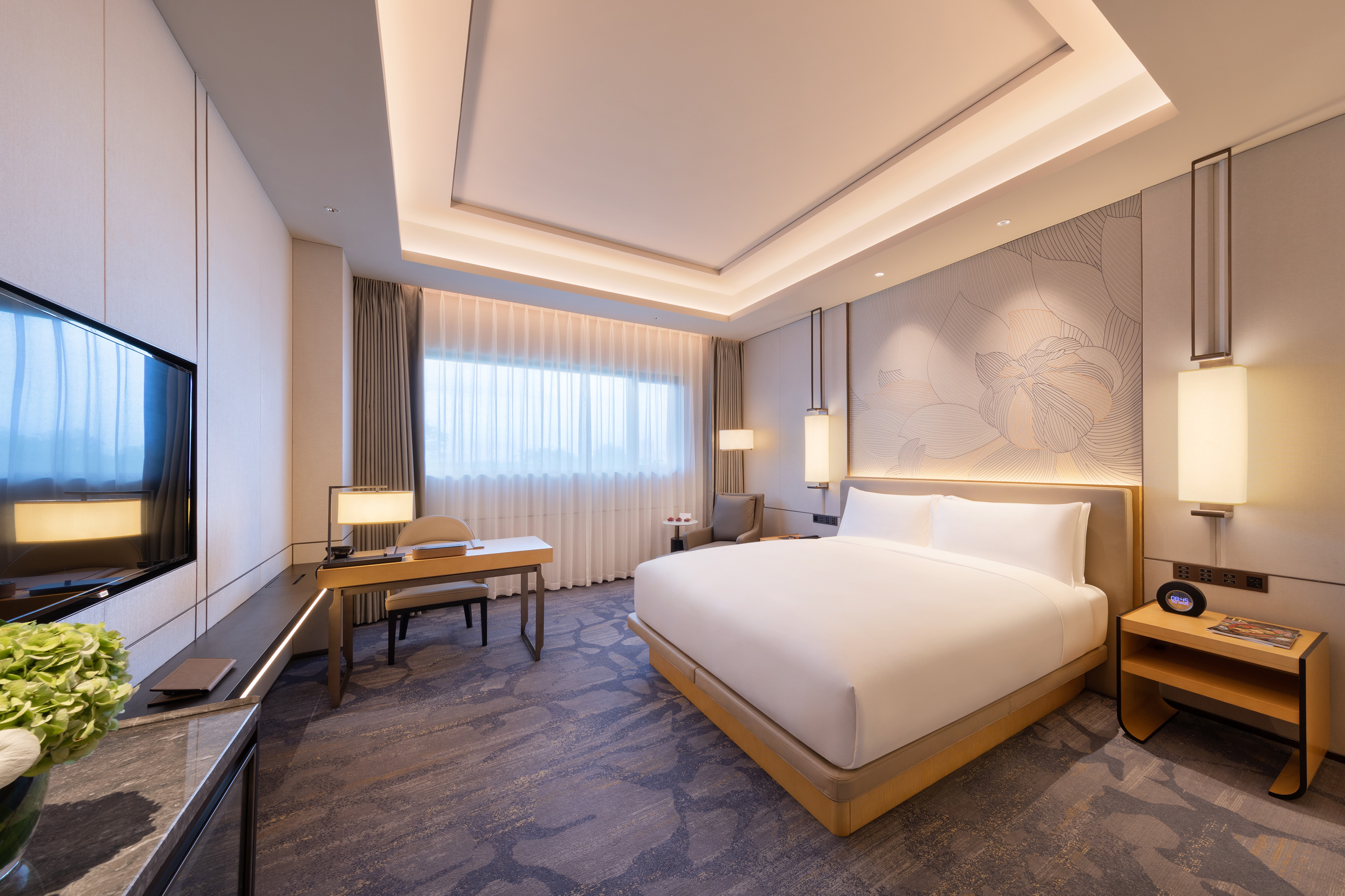 Modern luxury hotel room with king bed, work desk, and sophisticated decor.