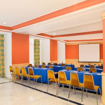 a room with orange walls and blue tables and chairs