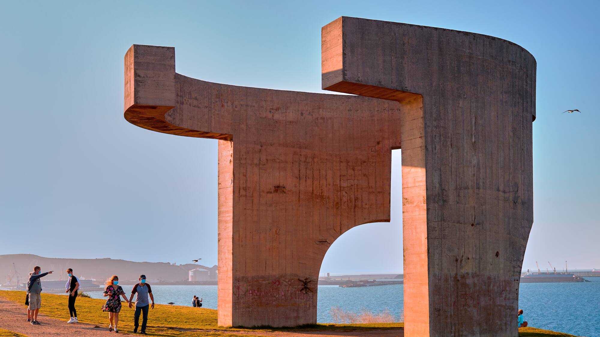 a group of people standing next to a large sculpture
