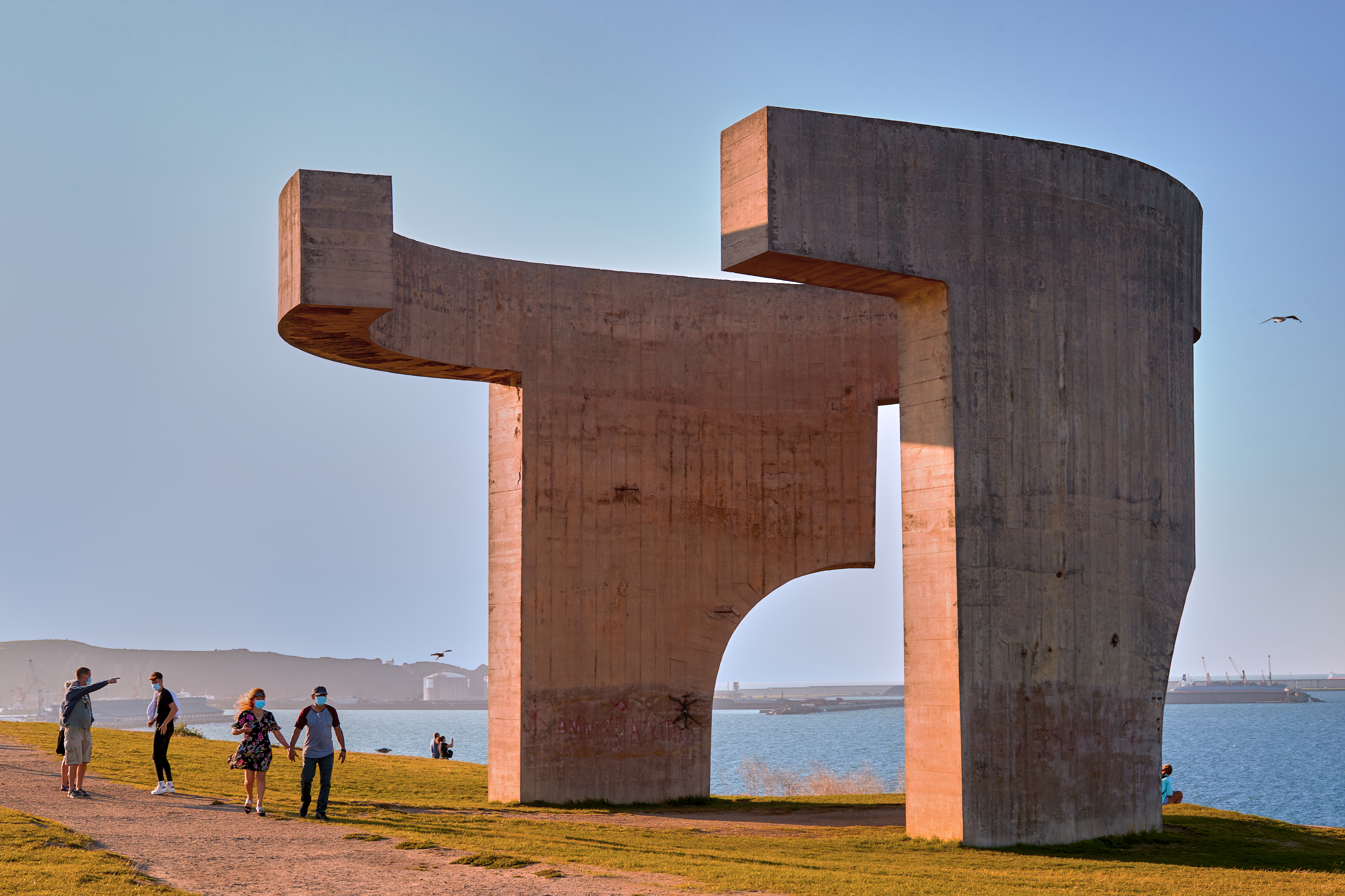 a group of people standing next to a large sculpture