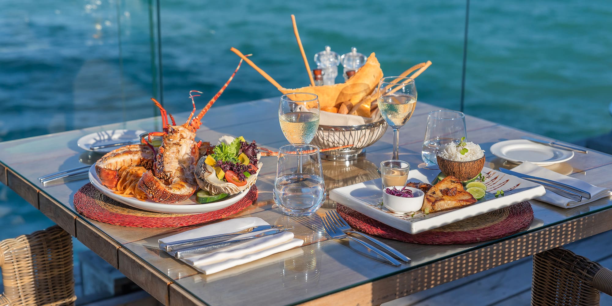 Luxurious oceanfront dining with grilled lobster, fish, and wine.