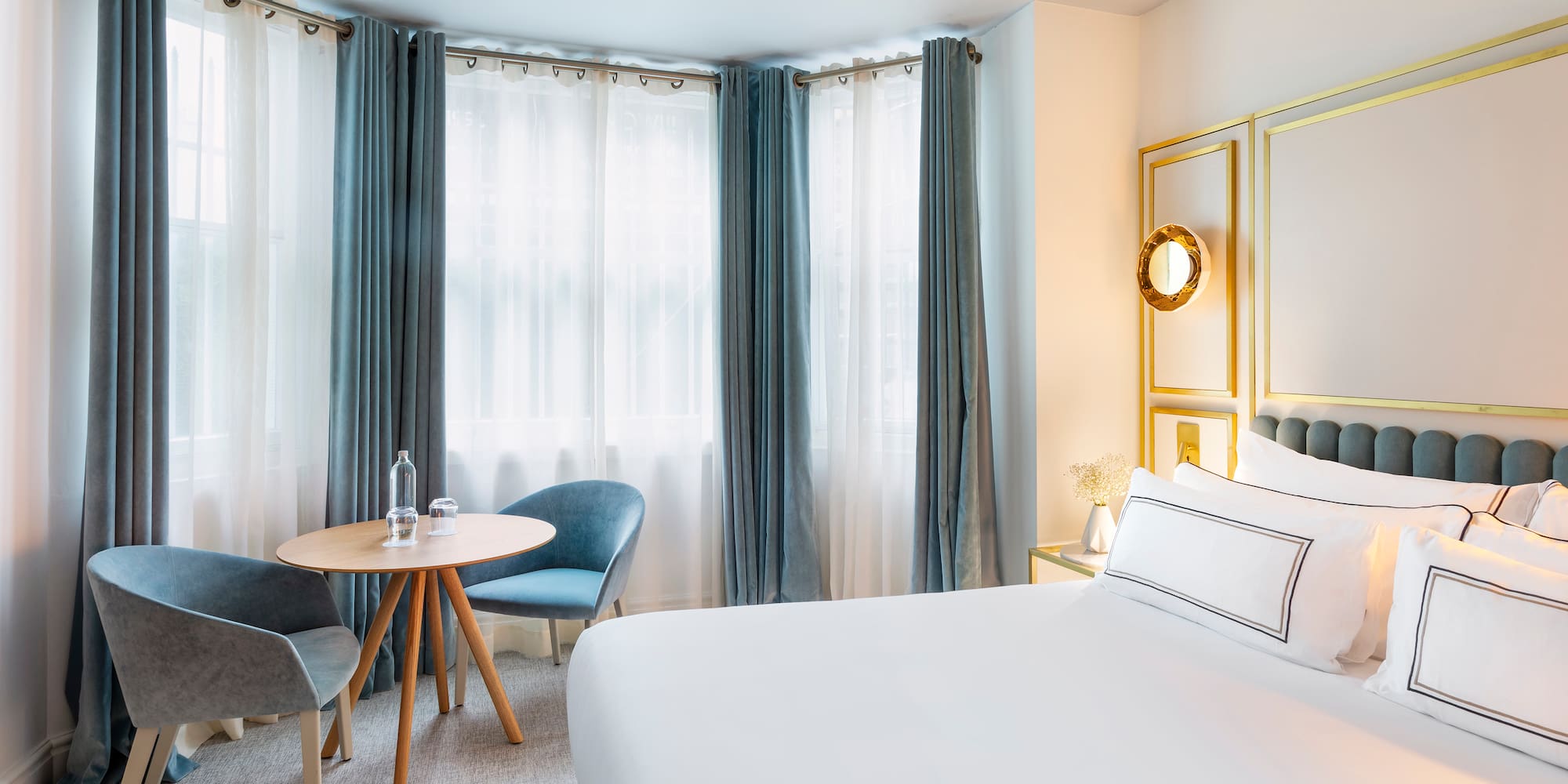 a room with a bed and chairs