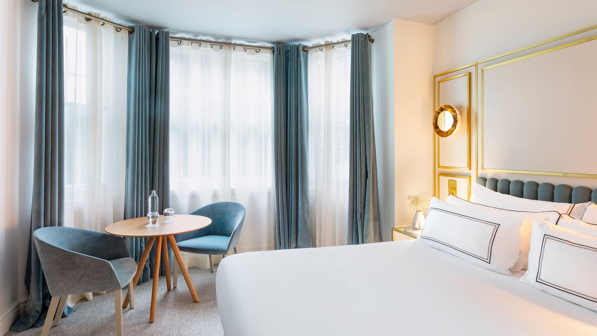 a room with a bed and chairs