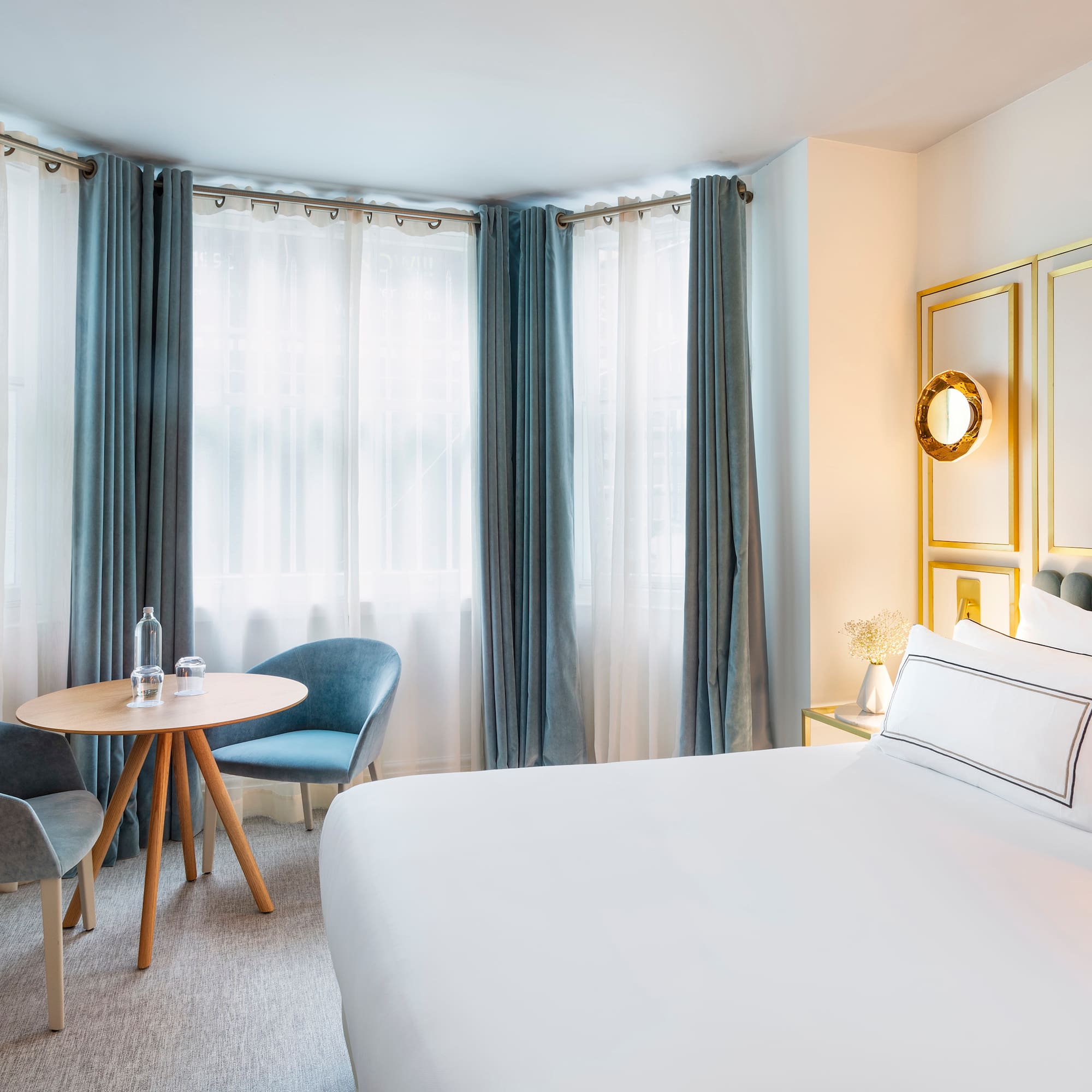 a room with a bed and chairs