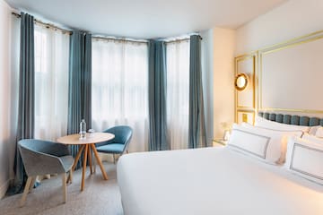 a room with a bed and chairs