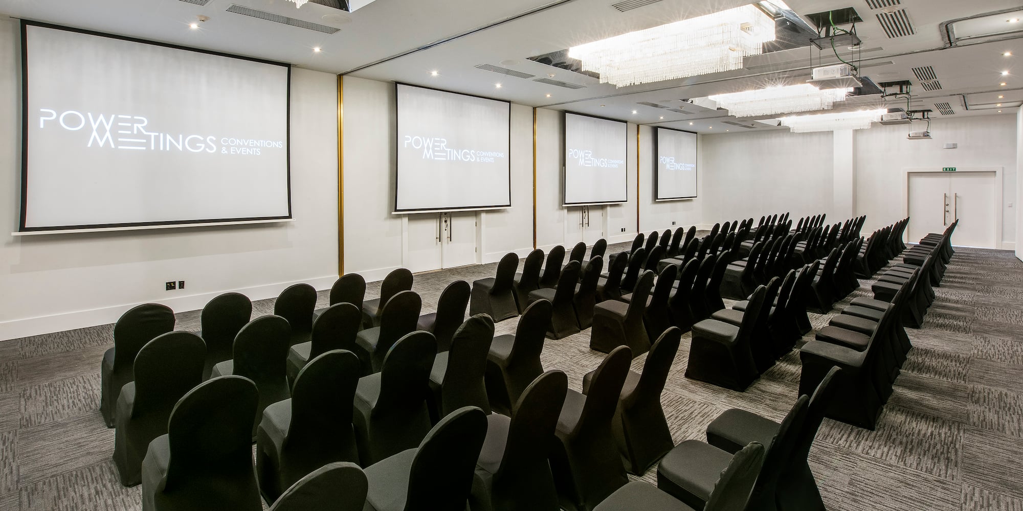 a room with chairs and projector screens
