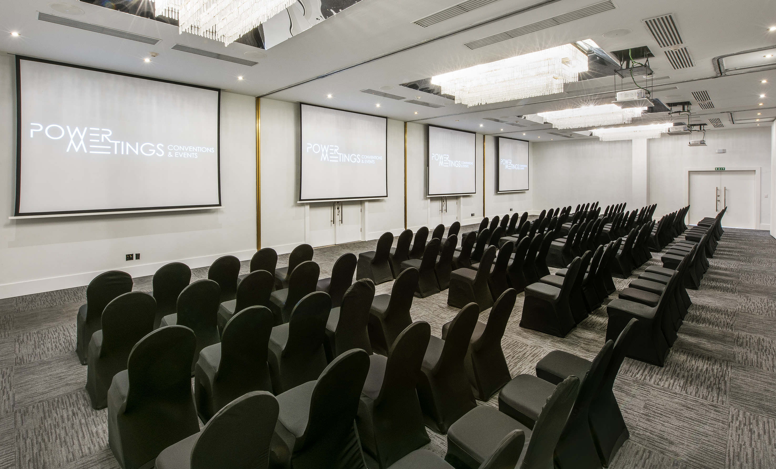 a room with chairs and projector screens