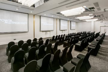 a room with chairs and projector screens