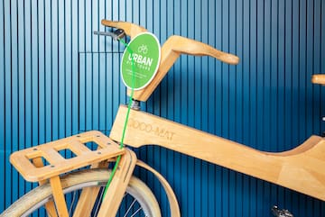a wooden bicycle with a green label attached to it