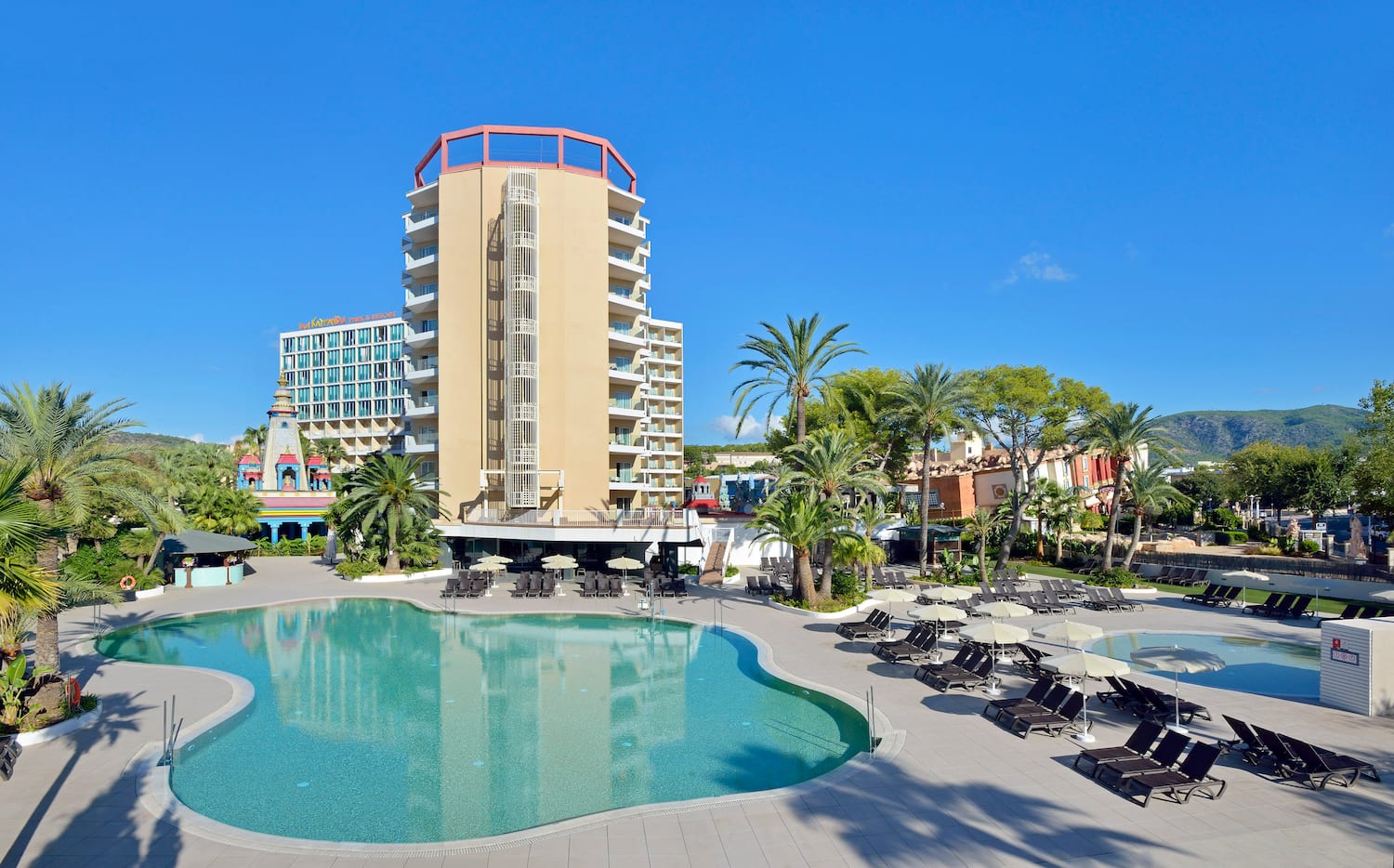 a pool with lounge chairs and a building in the background