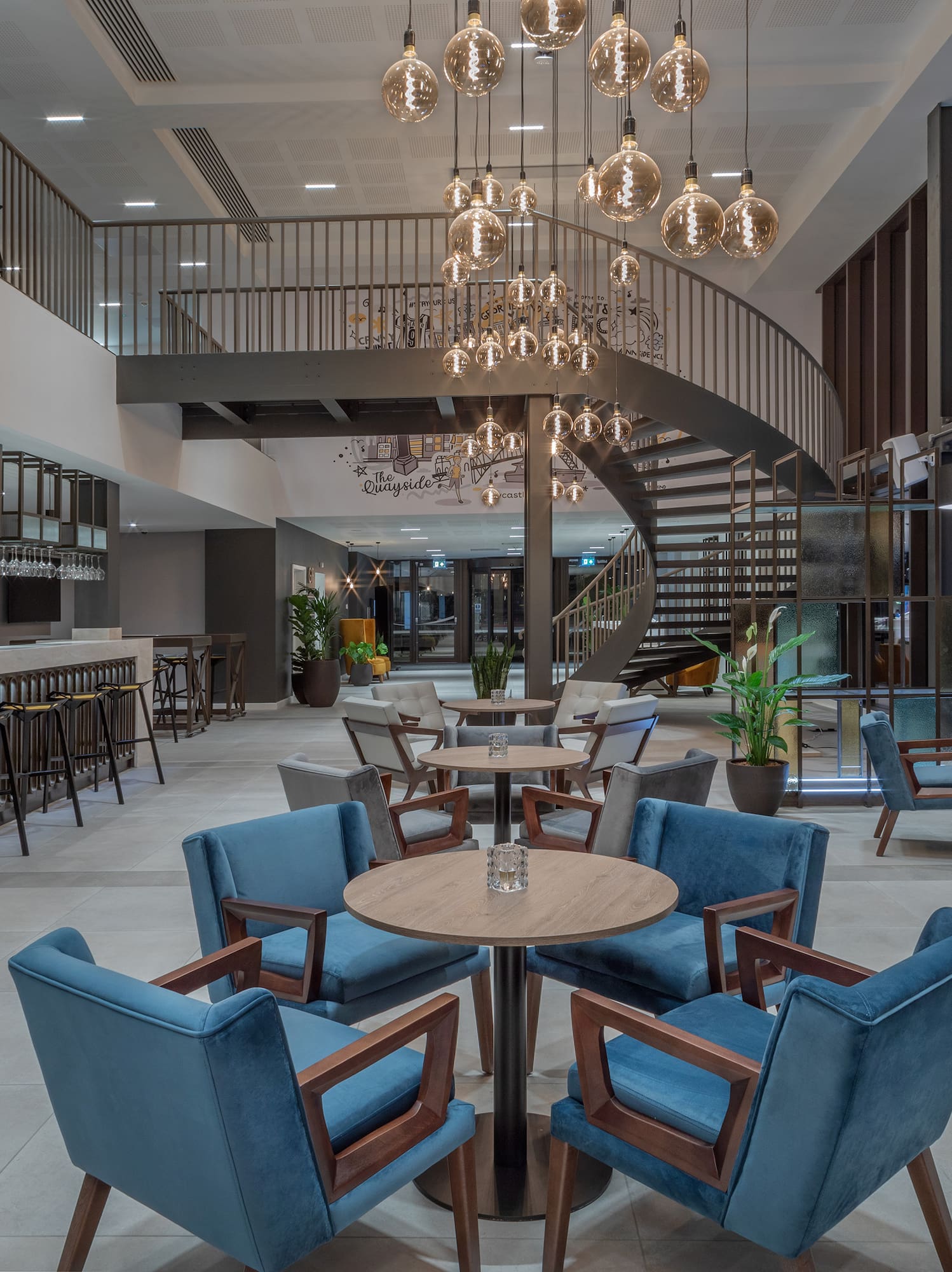 a room with a spiral staircase and tables and chairs