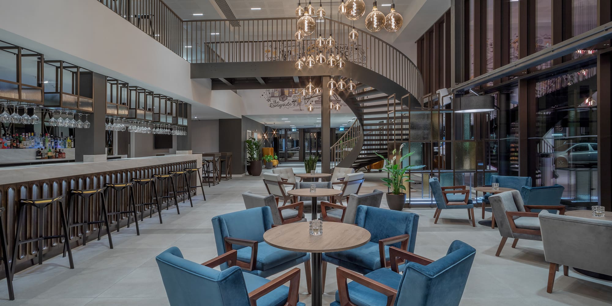 a room with a spiral staircase and tables and chairs