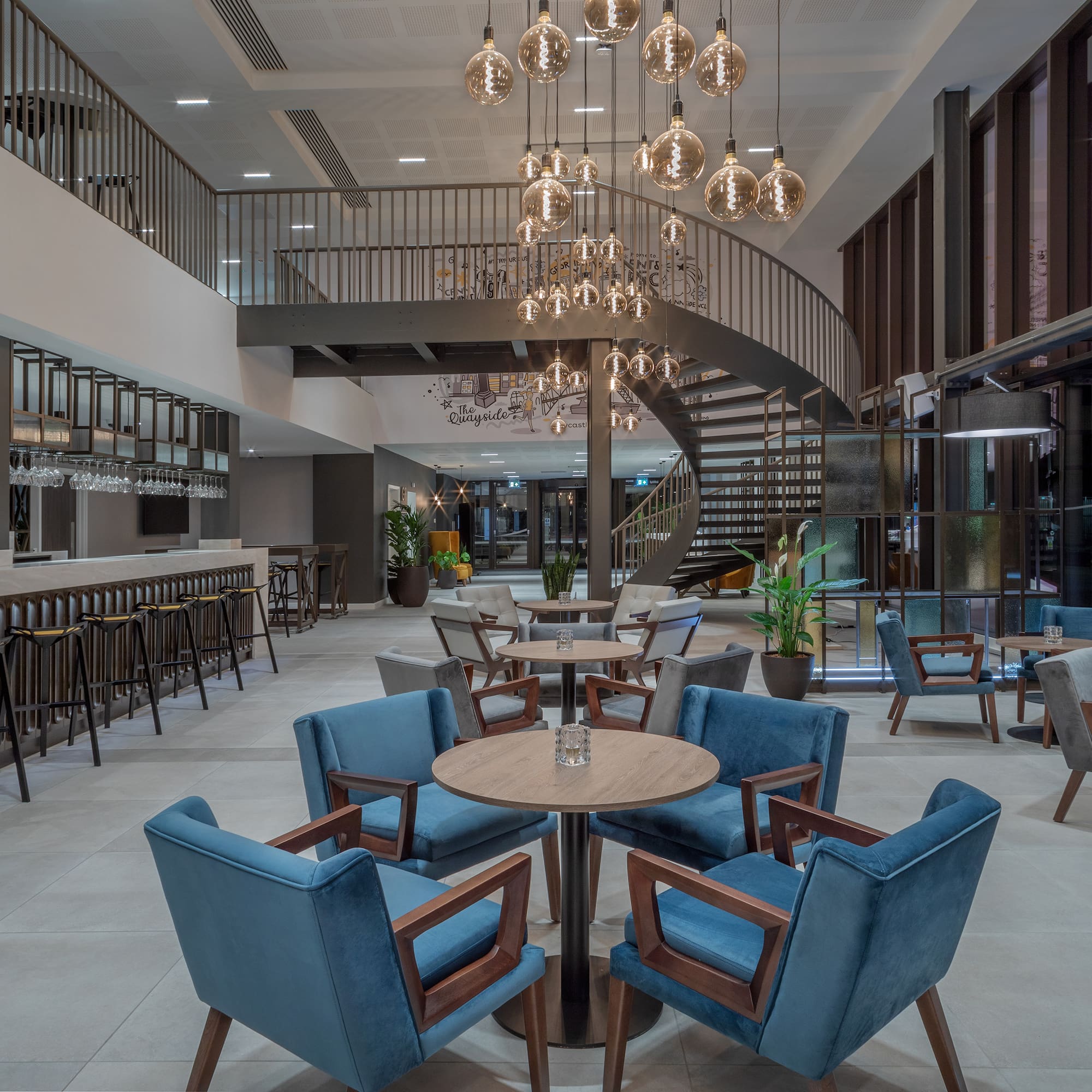 a room with a spiral staircase and tables and chairs