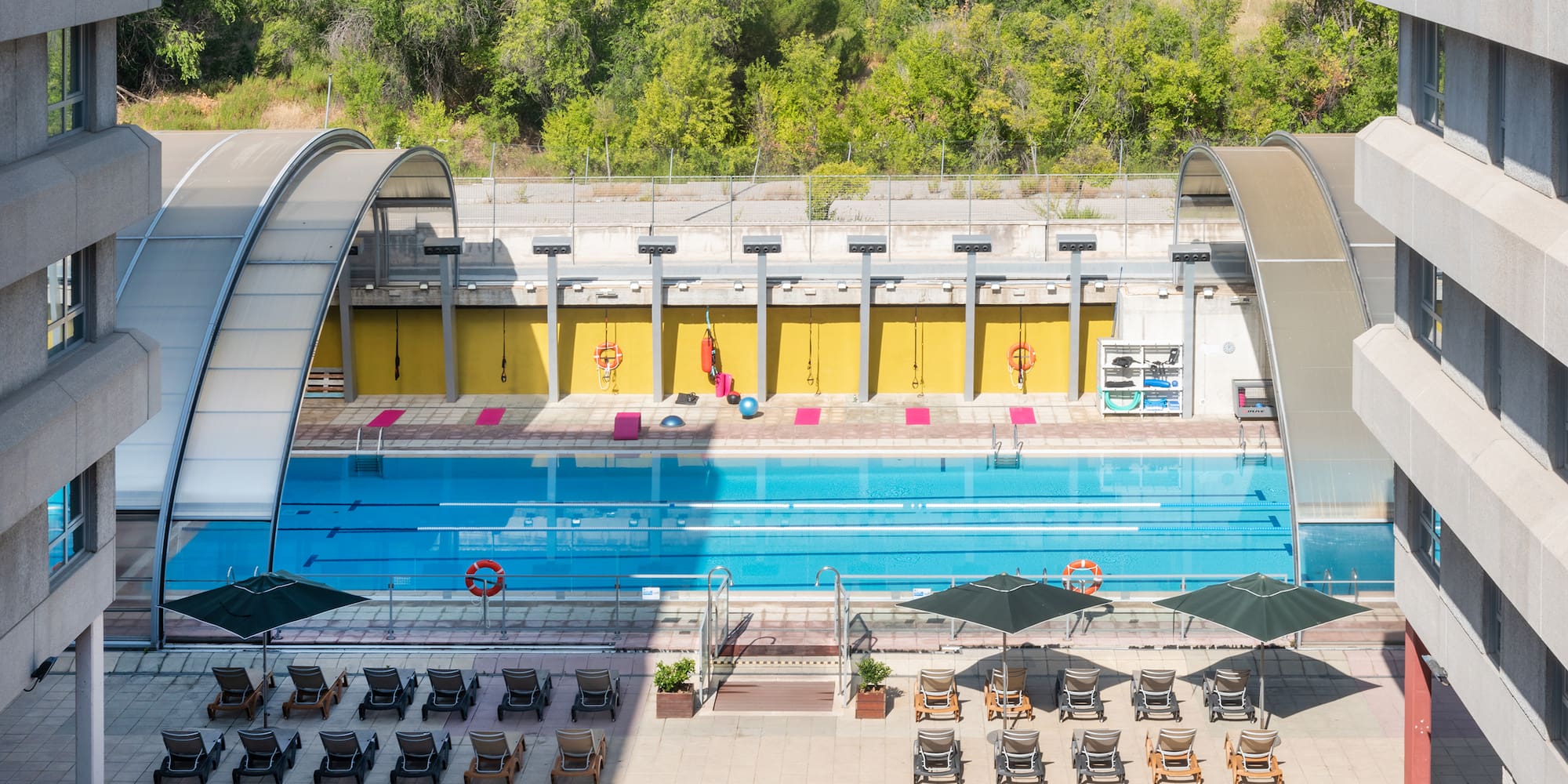 a swimming pool with chairs and umbrellas