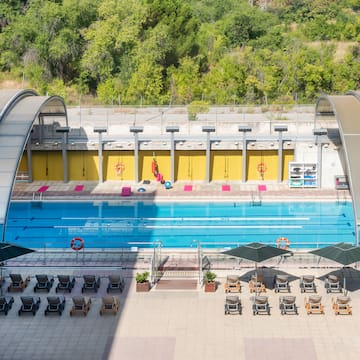 a swimming pool with chairs and umbrellas