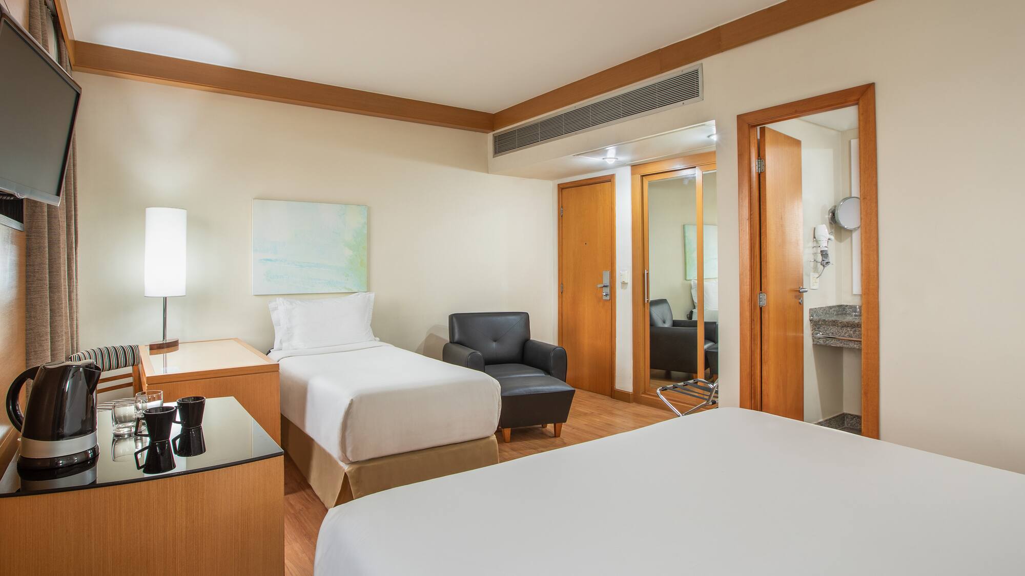 a room with two beds and a chair