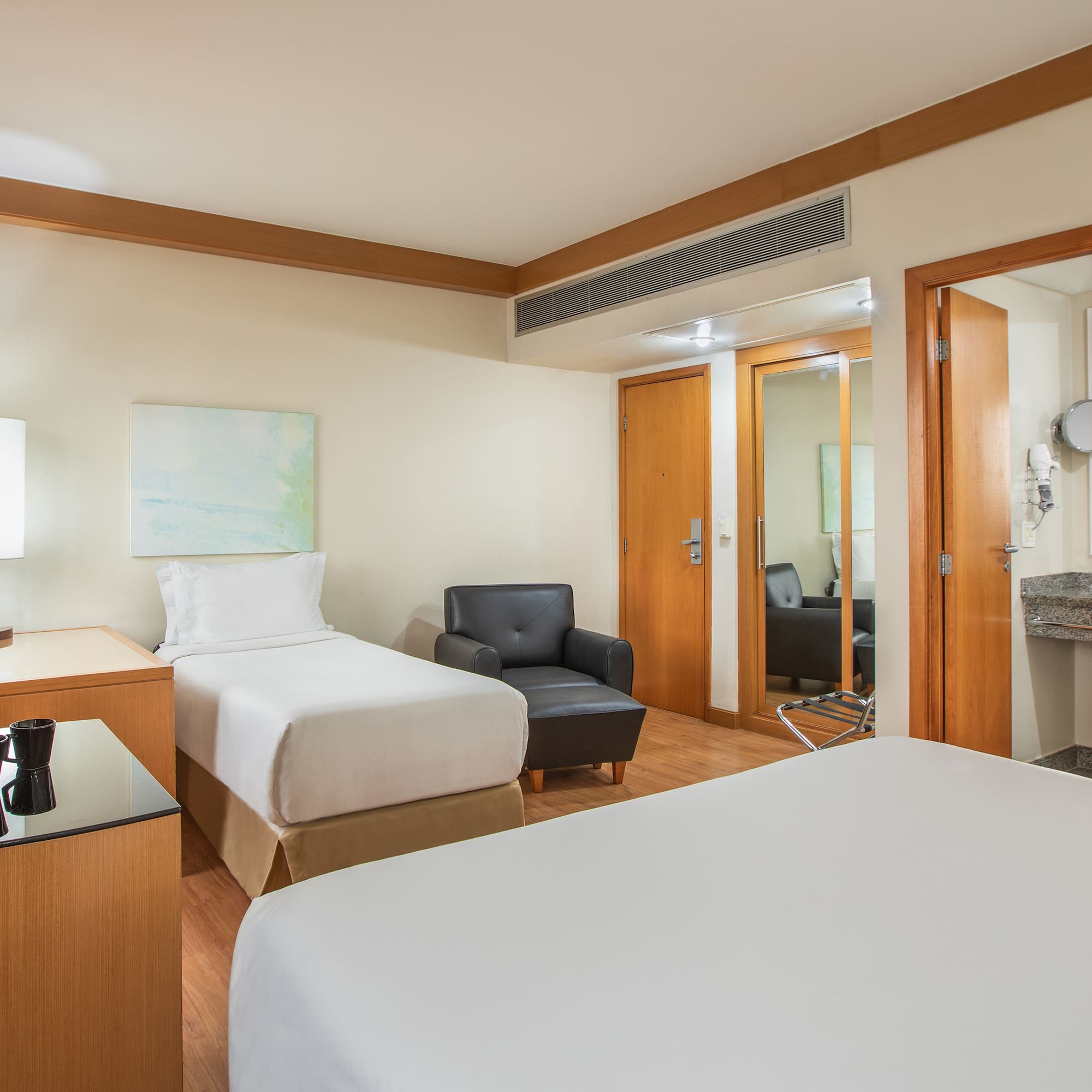 a room with two beds and a chair