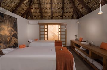 a room with two beds and a wooden ceiling