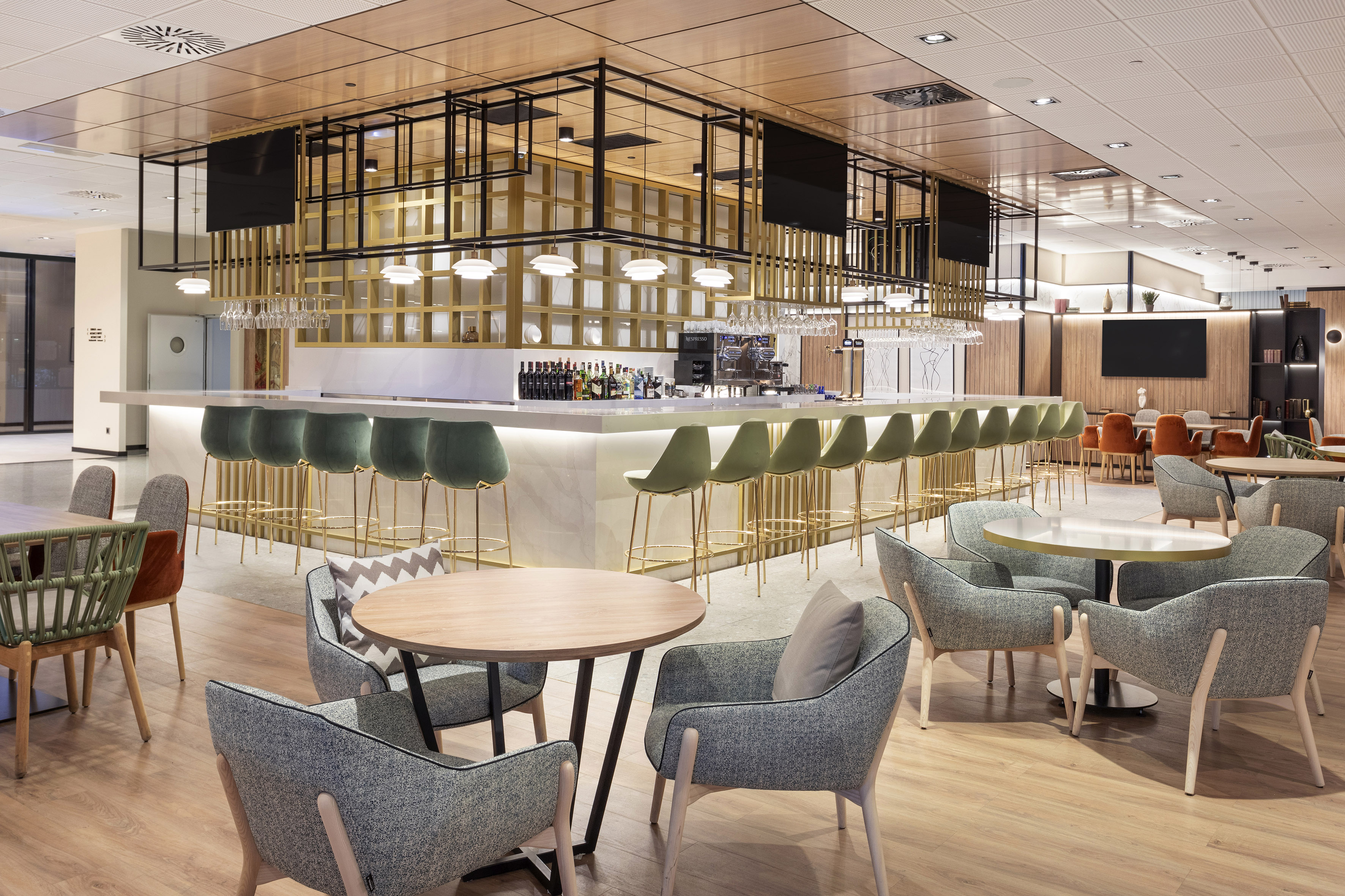 Modern hotel bar and lounge with olive green stools and contemporary seating.