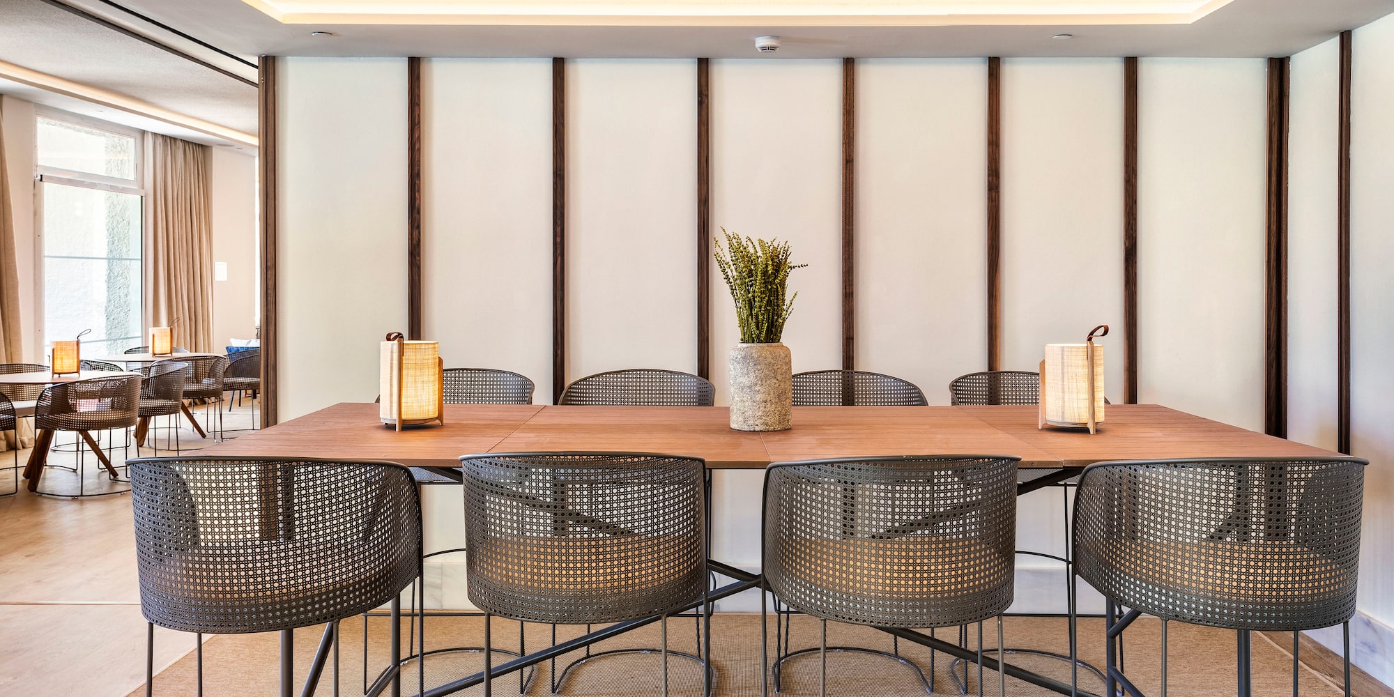 a table with chairs and a vase of flowers