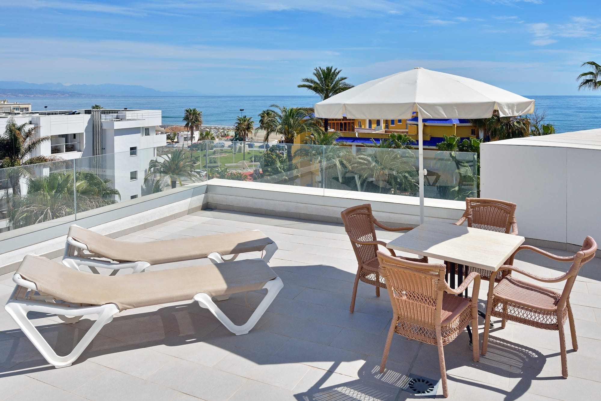 a patio with chairs and umbrella on a sunny day