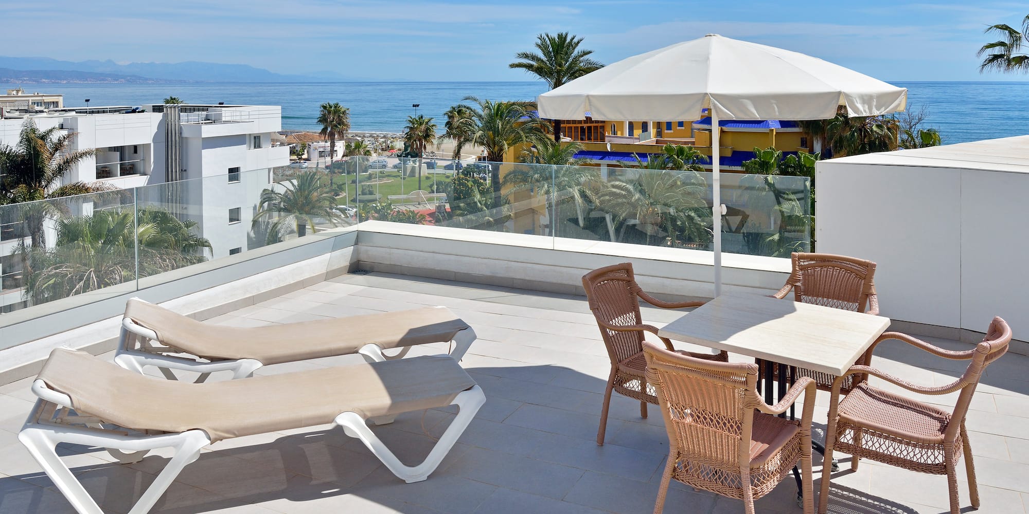 a patio with chairs and umbrella on a sunny day