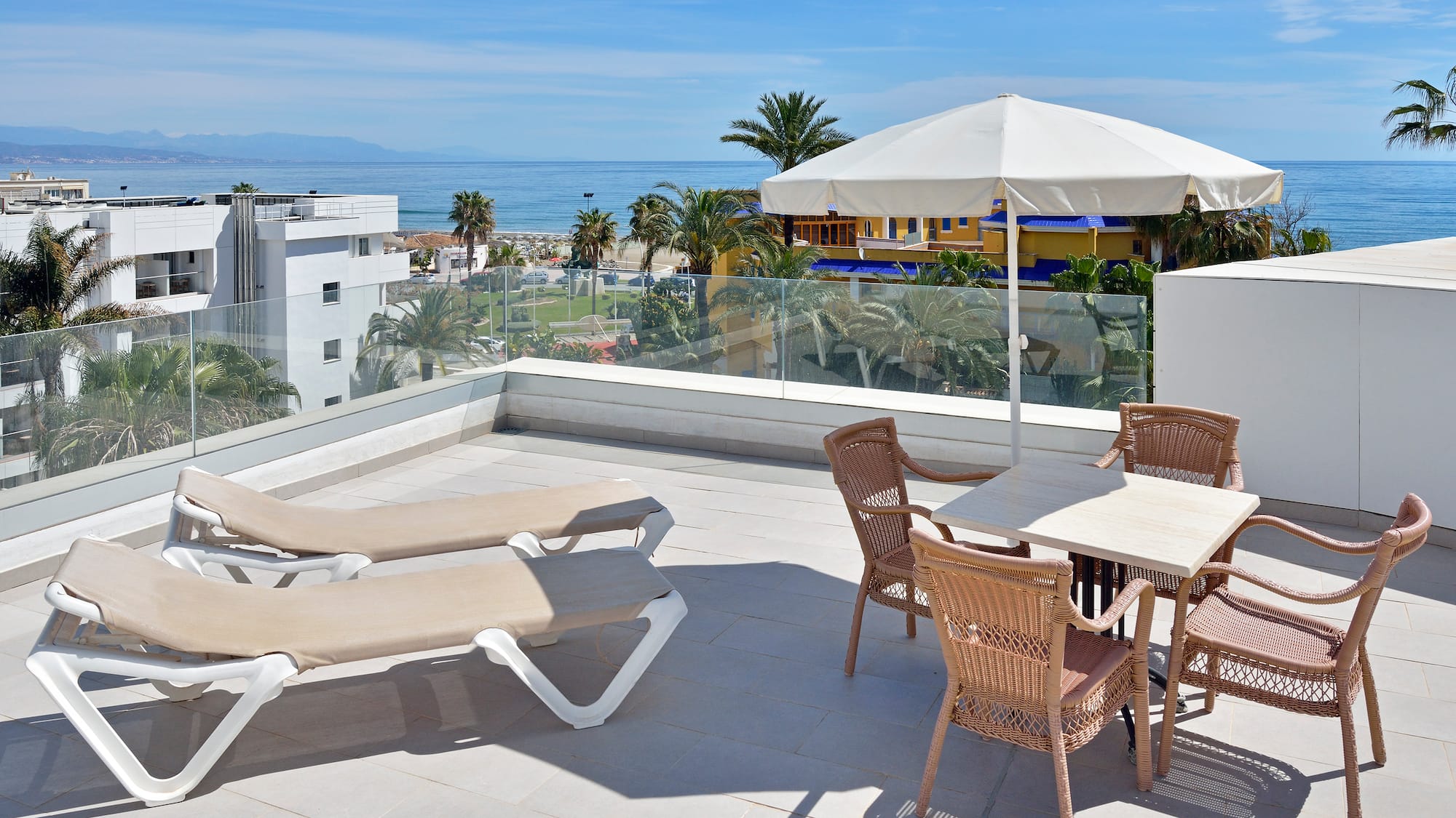 a patio with chairs and umbrella on a sunny day