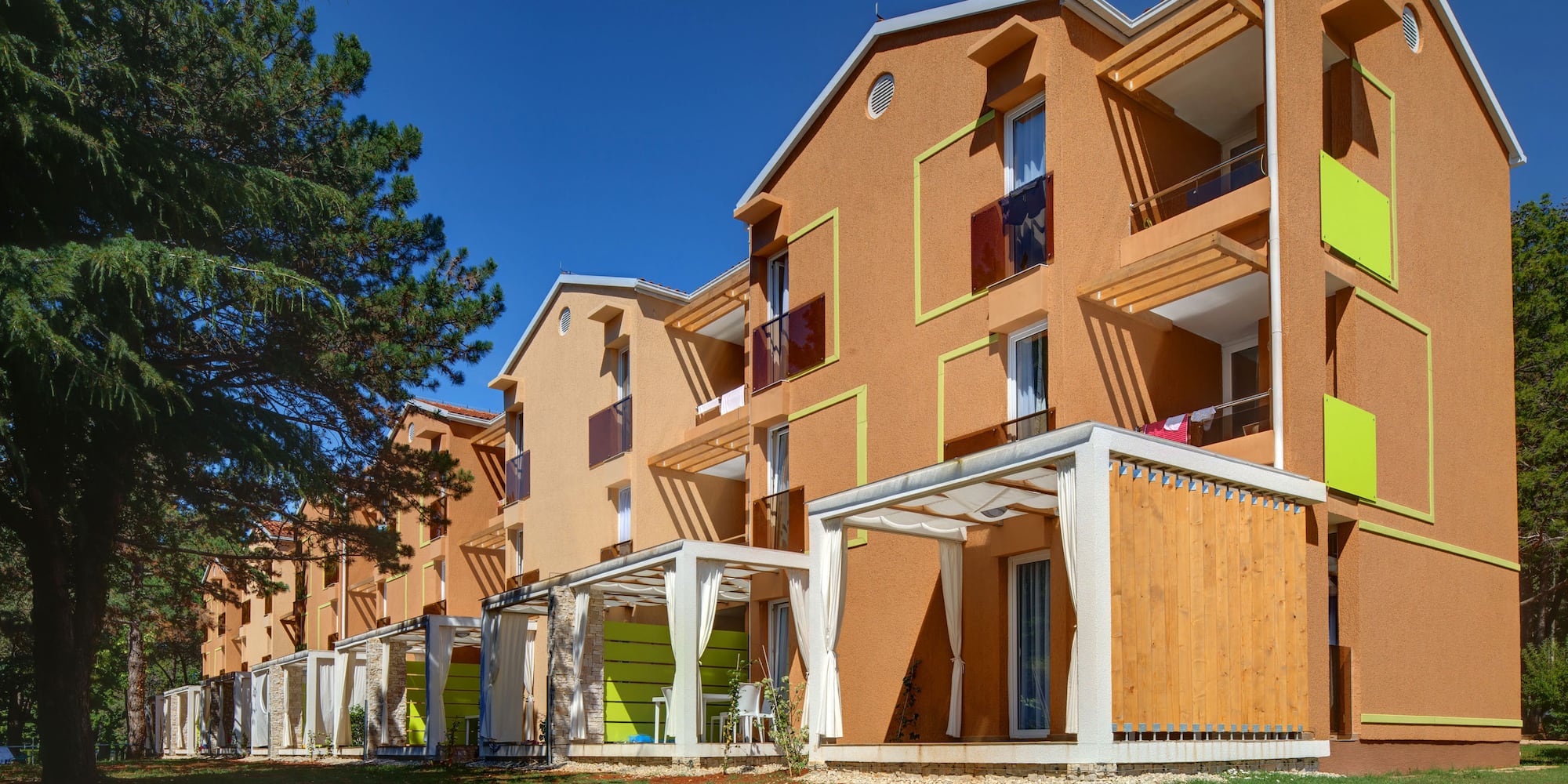 a building with a green lawn and trees