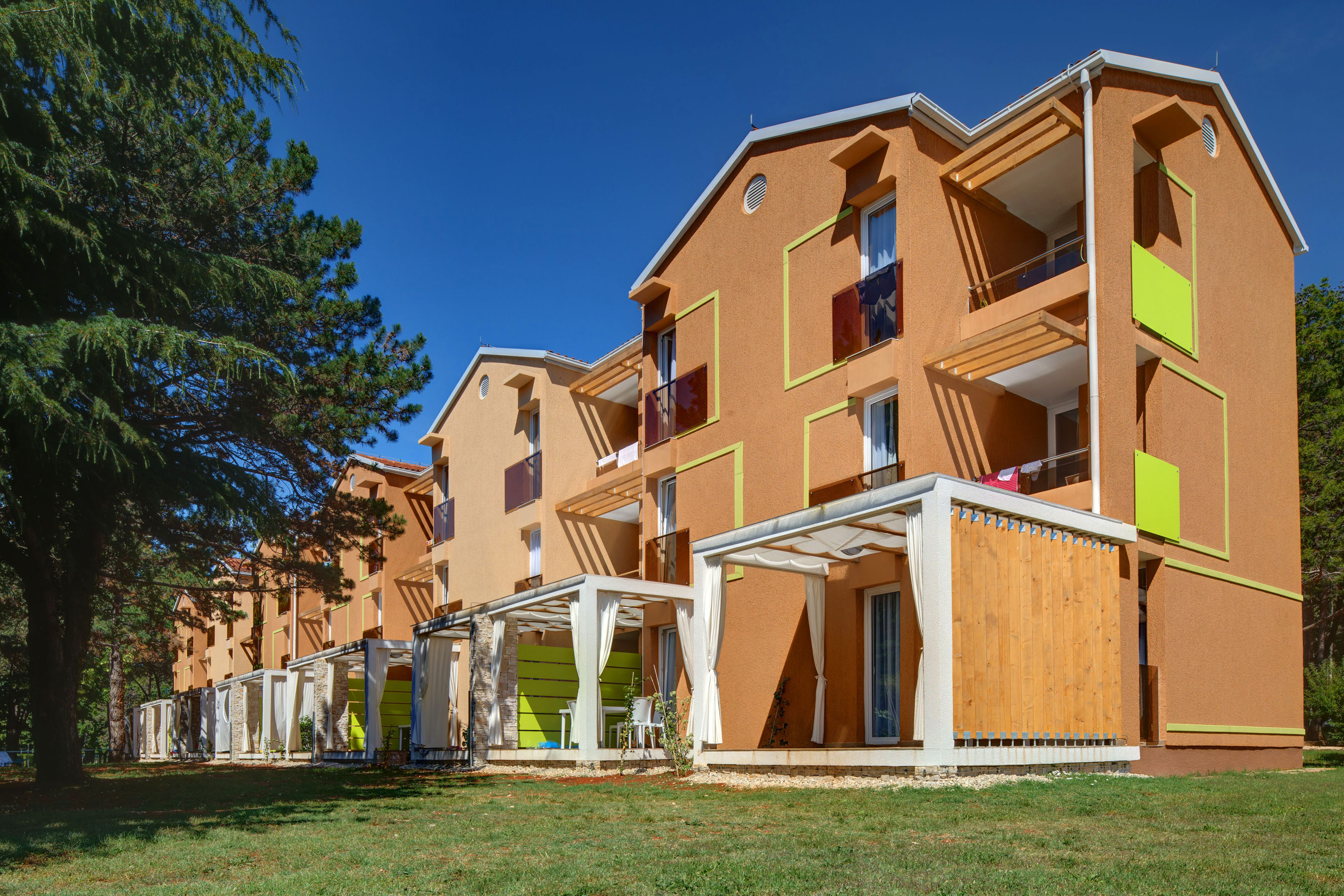 a building with a green lawn and trees