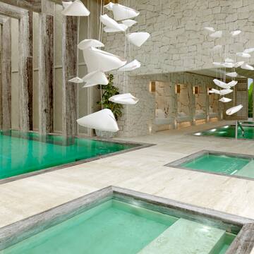 a swimming pool with a stone wall and a stone wall