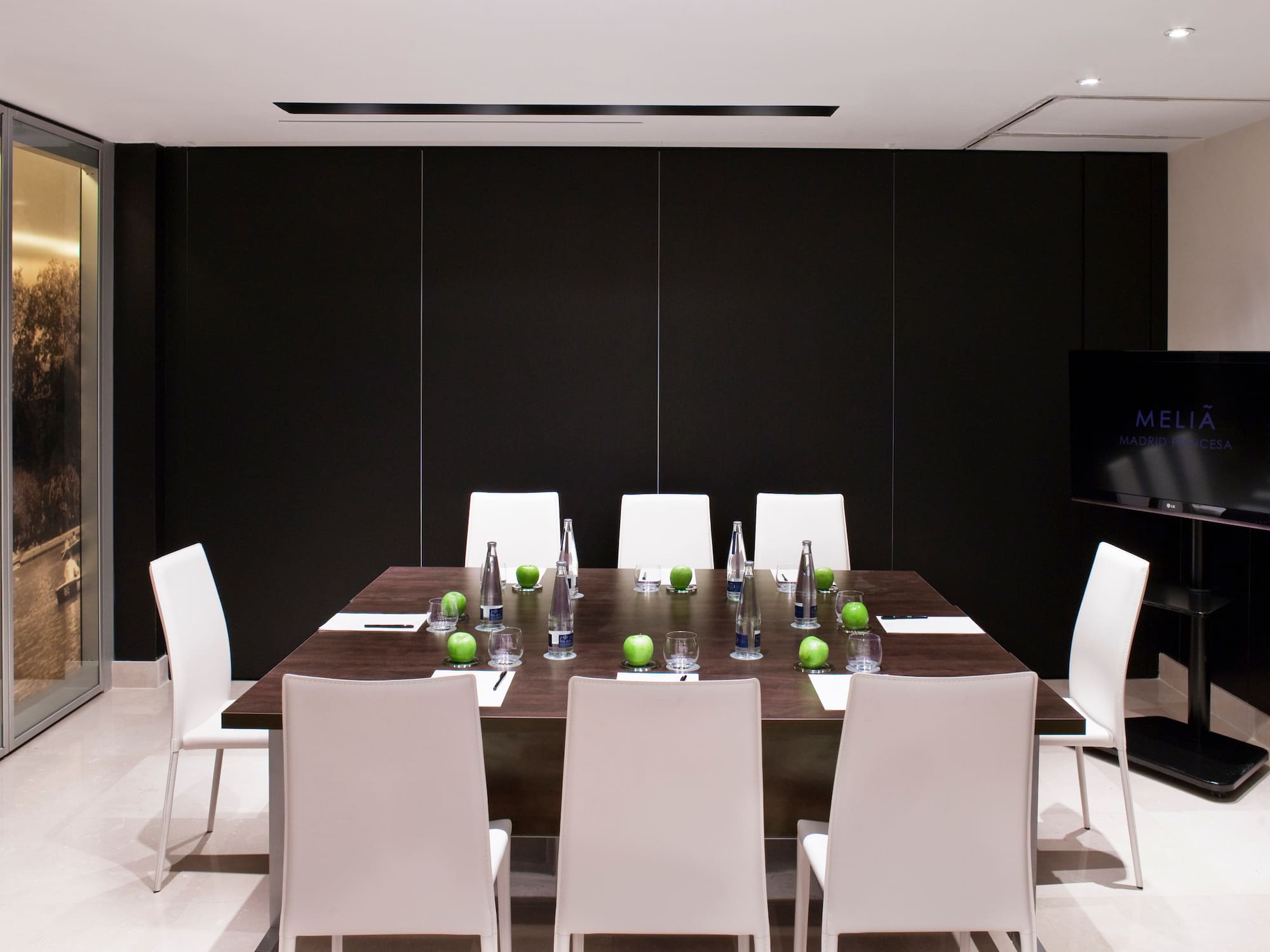 a table with white chairs and green apples on it