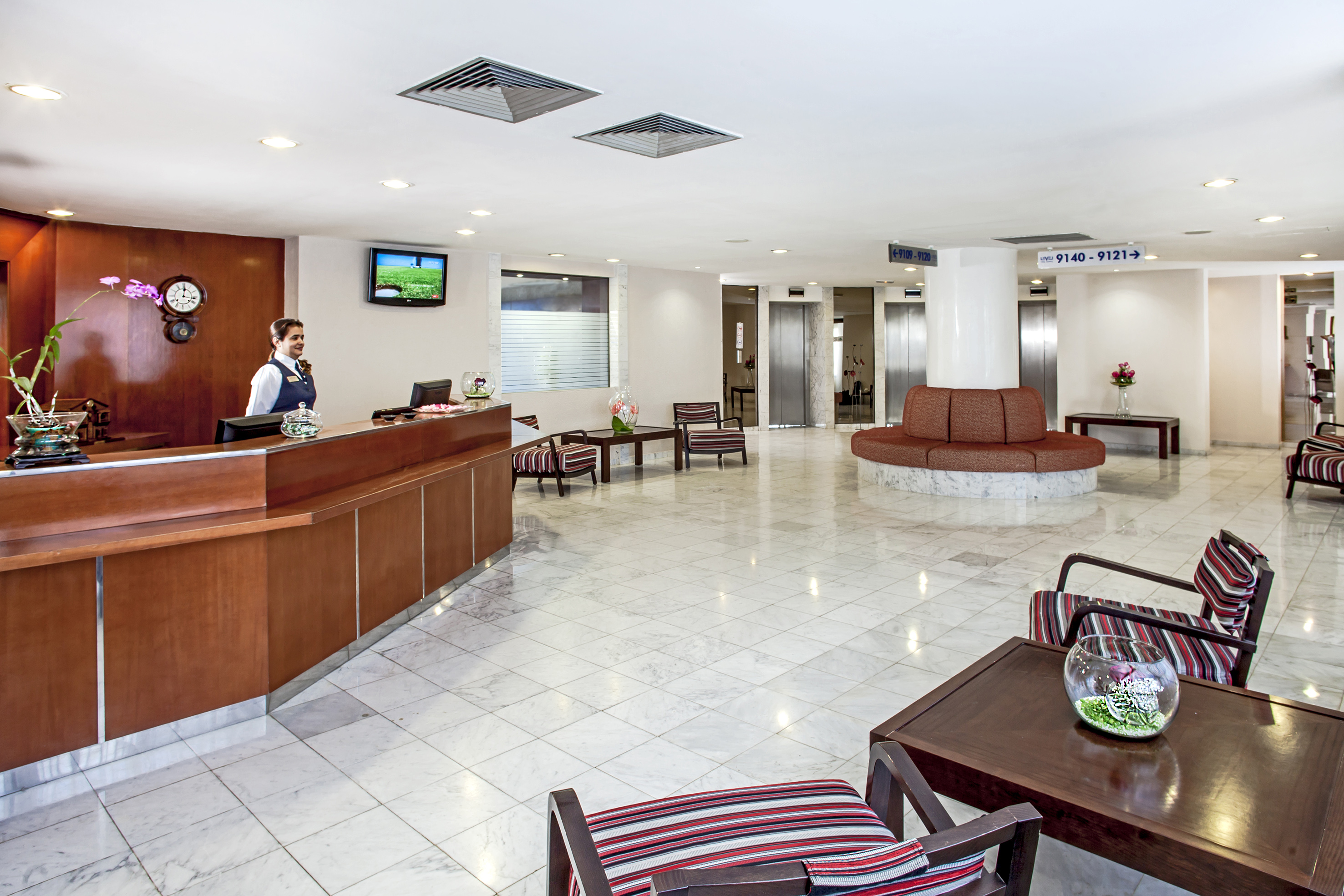 a lobby with a woman standing behind a counter