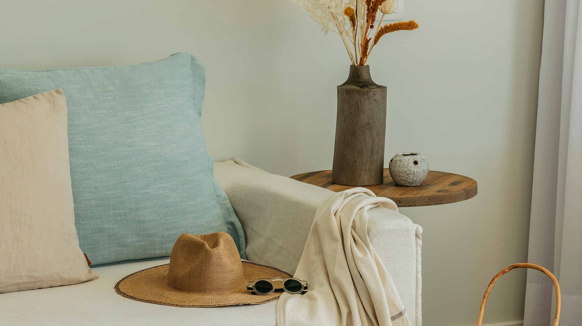 a white couch with a hat and sunglasses on a table