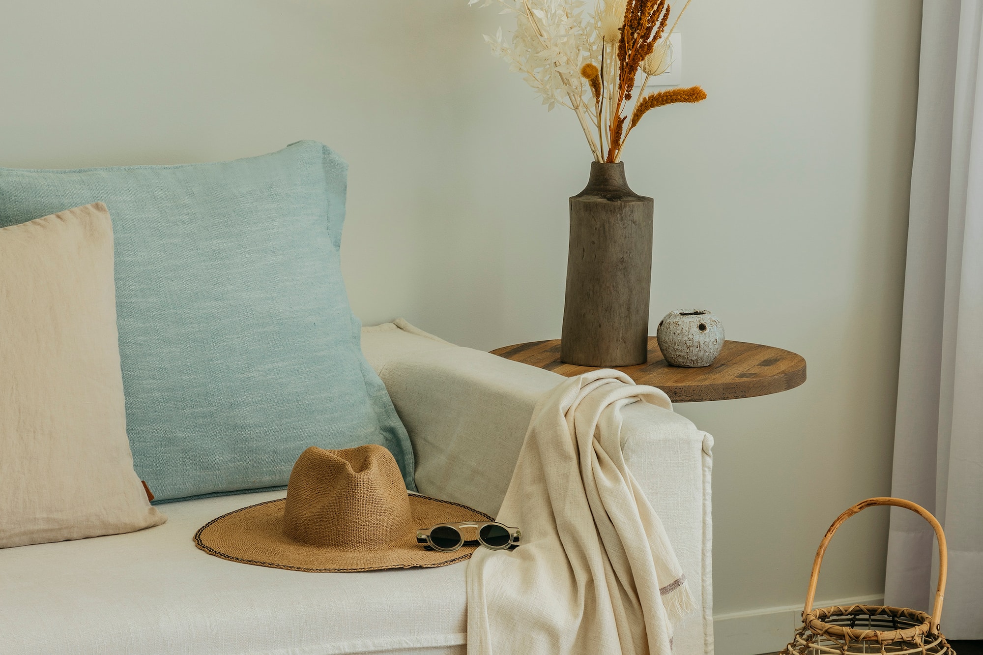 a white couch with a hat and sunglasses on a table