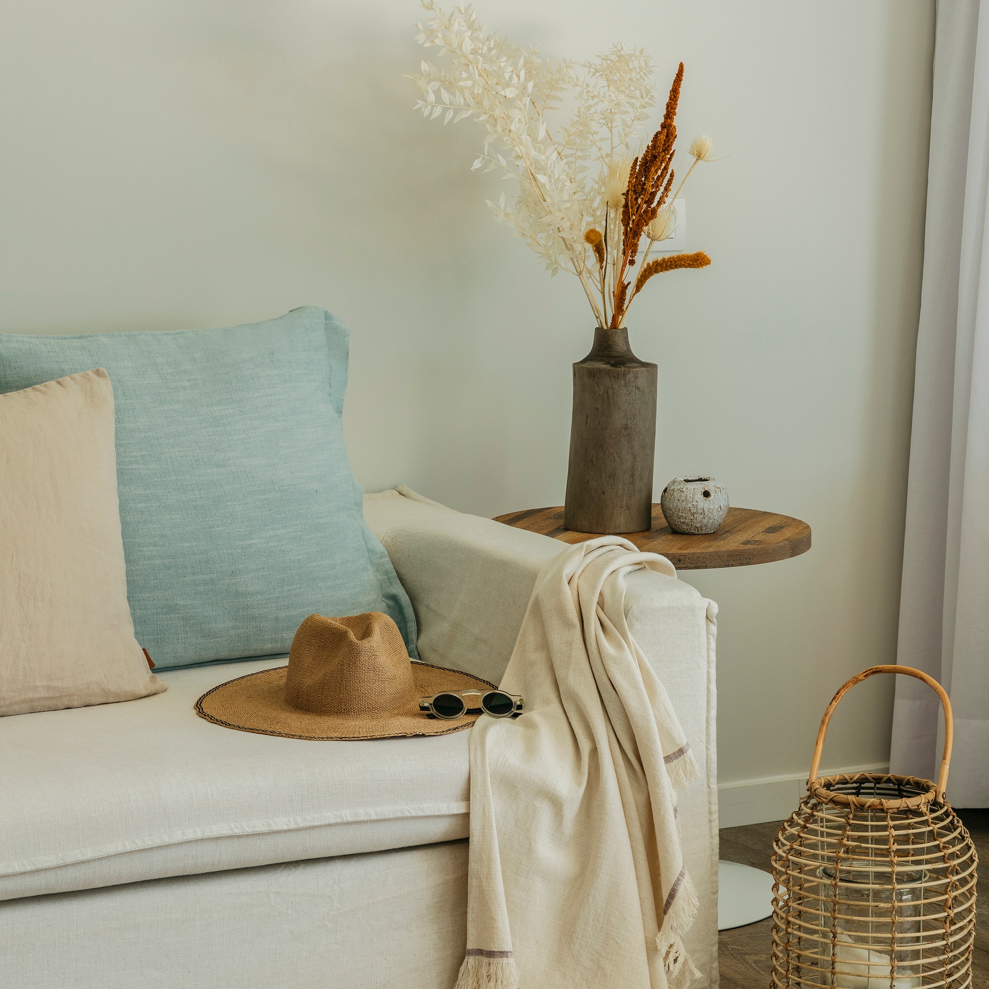 a white couch with a hat and sunglasses on a table