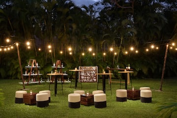 a group of tables and chairs in a grass area with lights