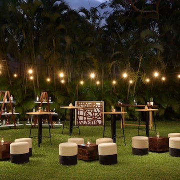 a group of tables and chairs in a grass area with lights