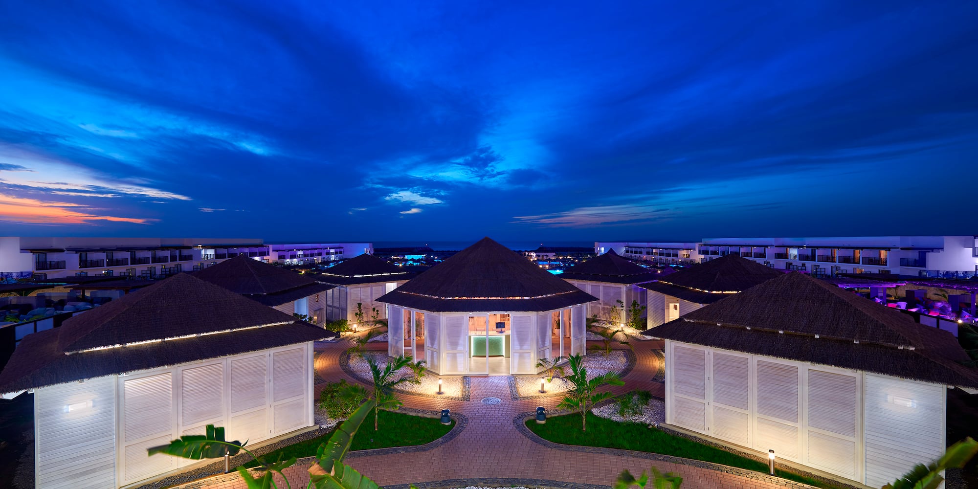 a group of houses with a circular walkway and a blue sky