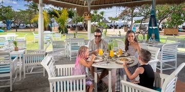 a family sitting at a table with food on it