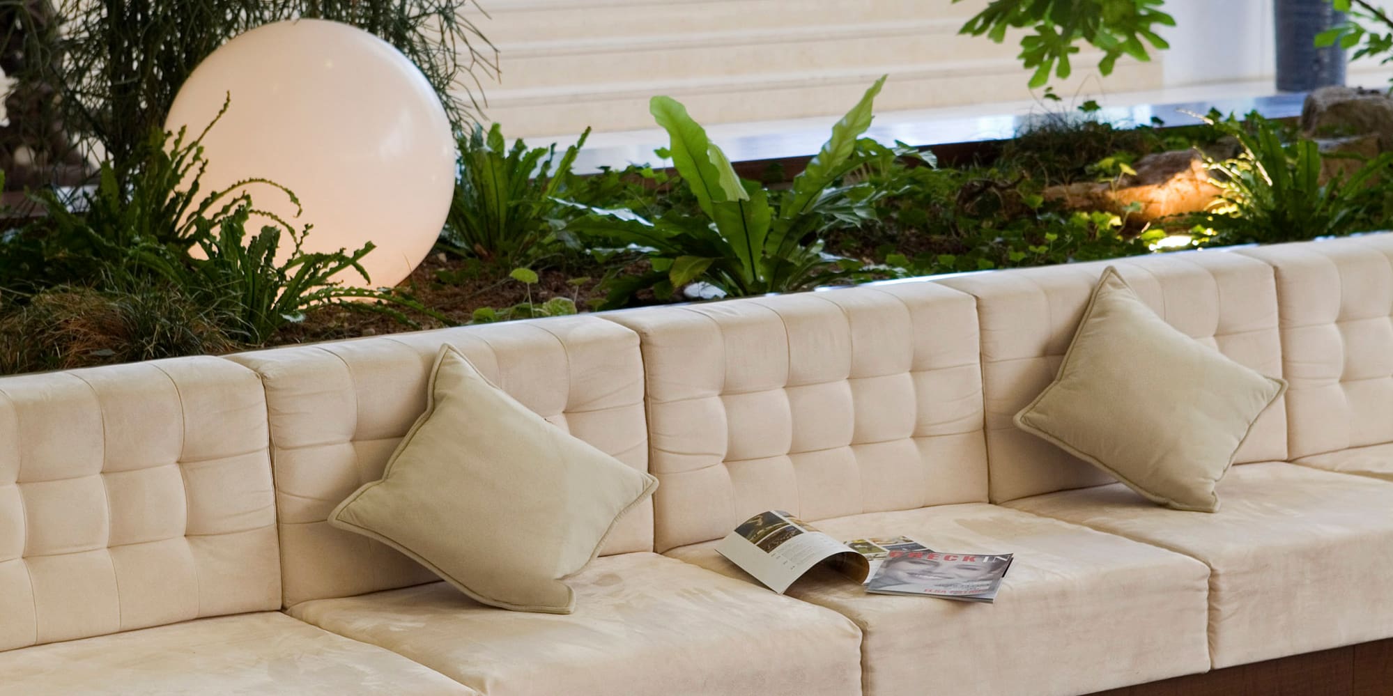 a white couch with pillows and a round table