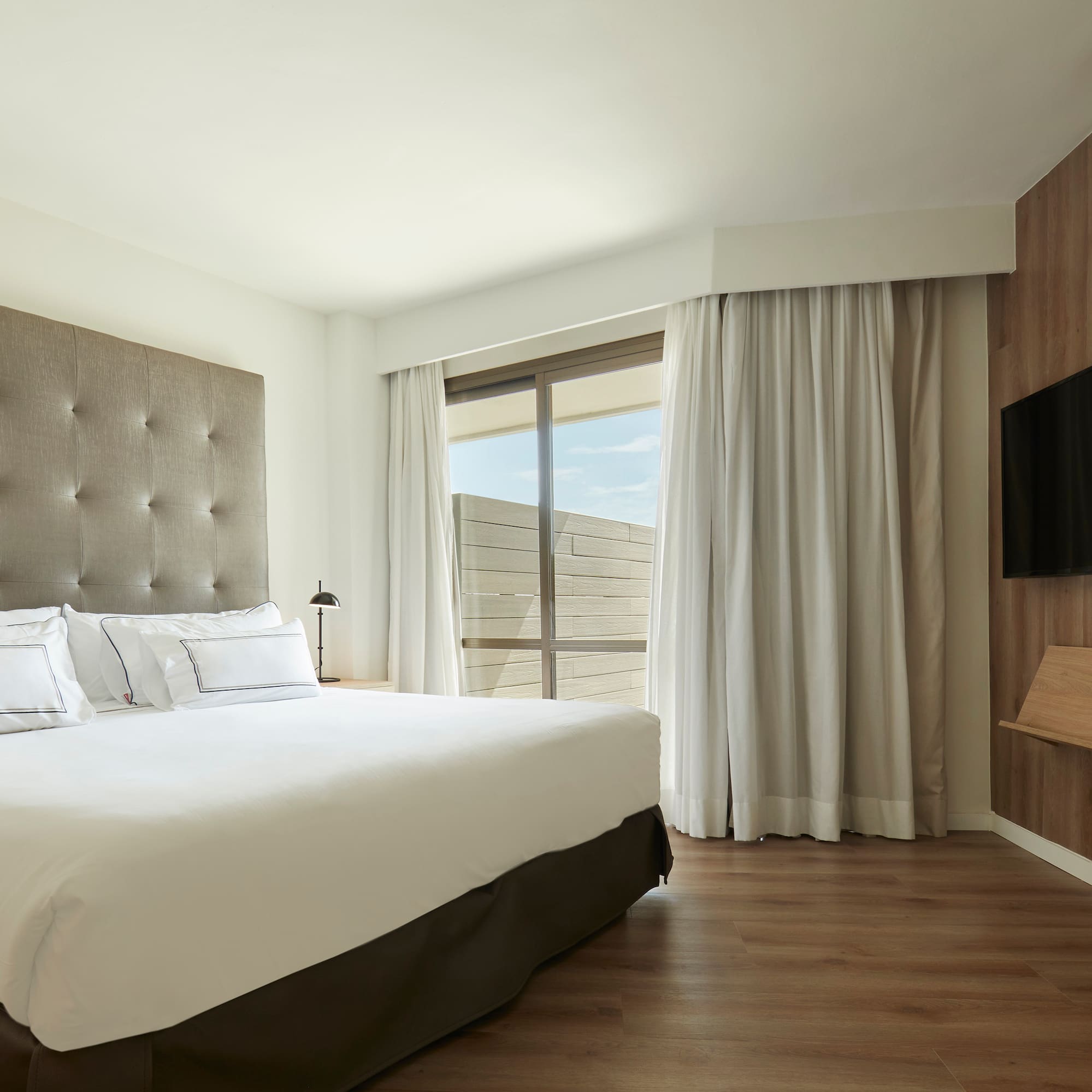 a bedroom with a large bed and a tv