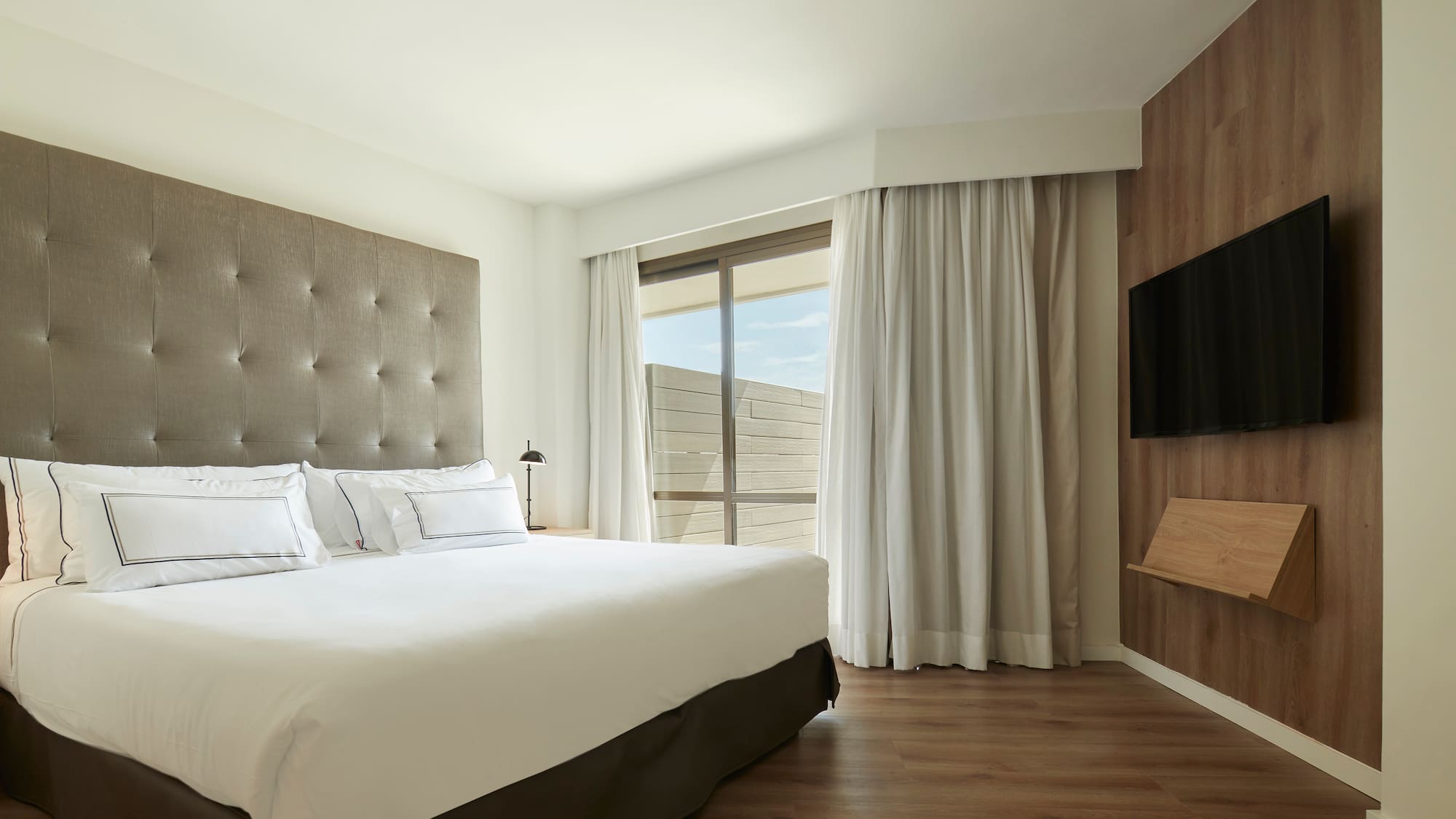 a bedroom with a large bed and a tv