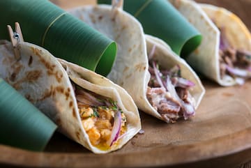 a group of tortillas on a wooden plate