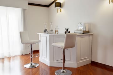 a white bar with stools and bottles on it