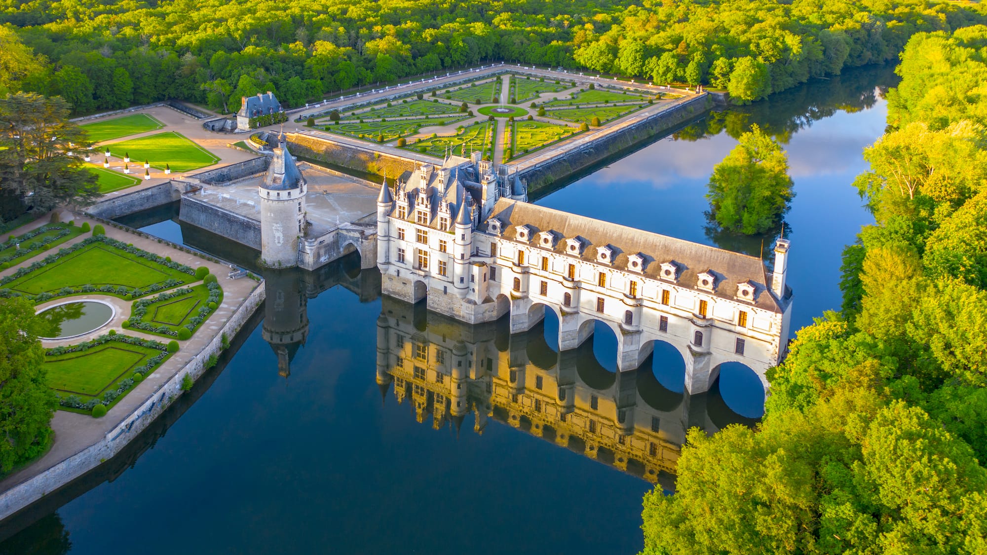 a castle with a large building and a pond
