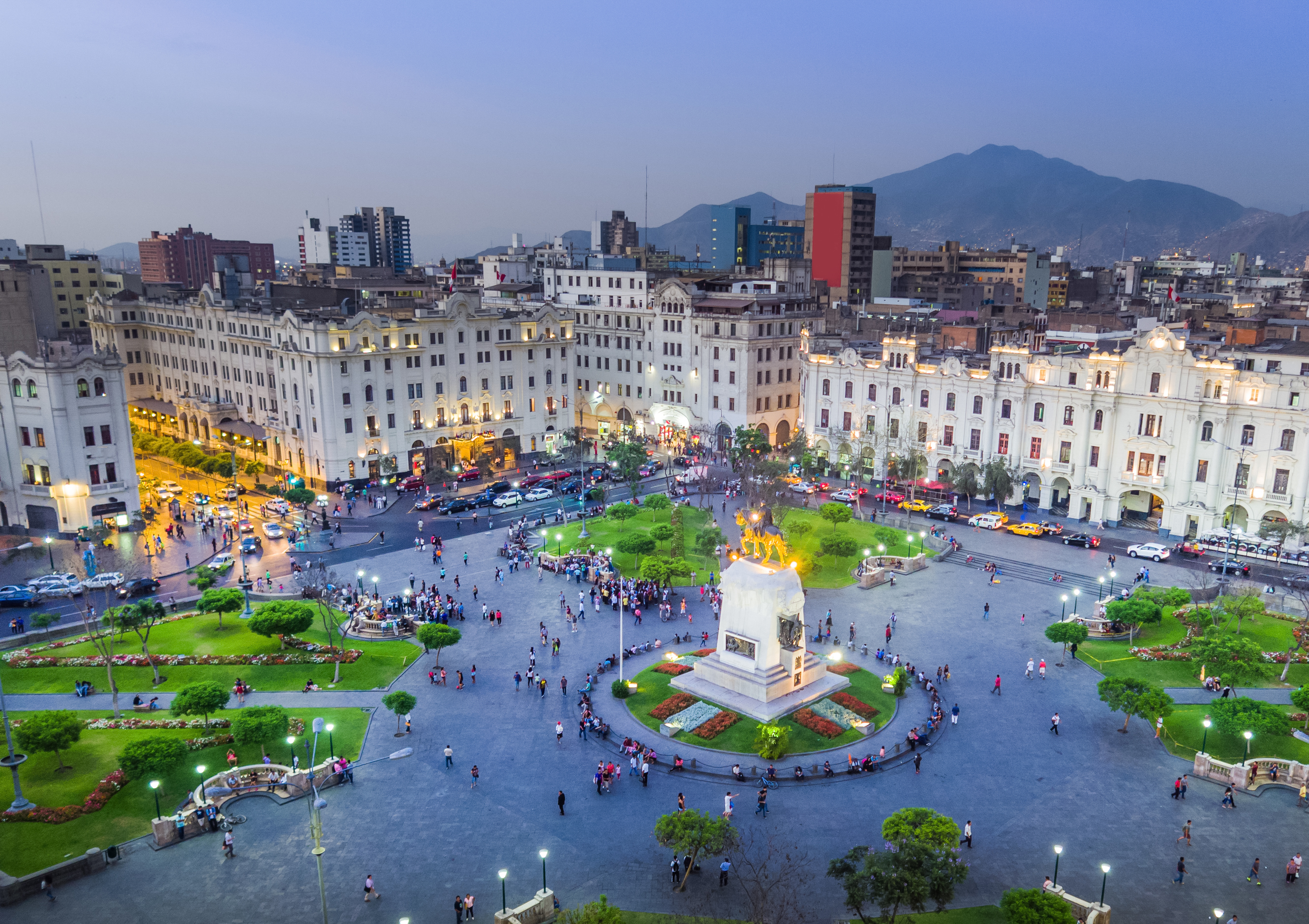 Plaza San Martín, Lima, Peru at dusk, with central monument and historic buildings.