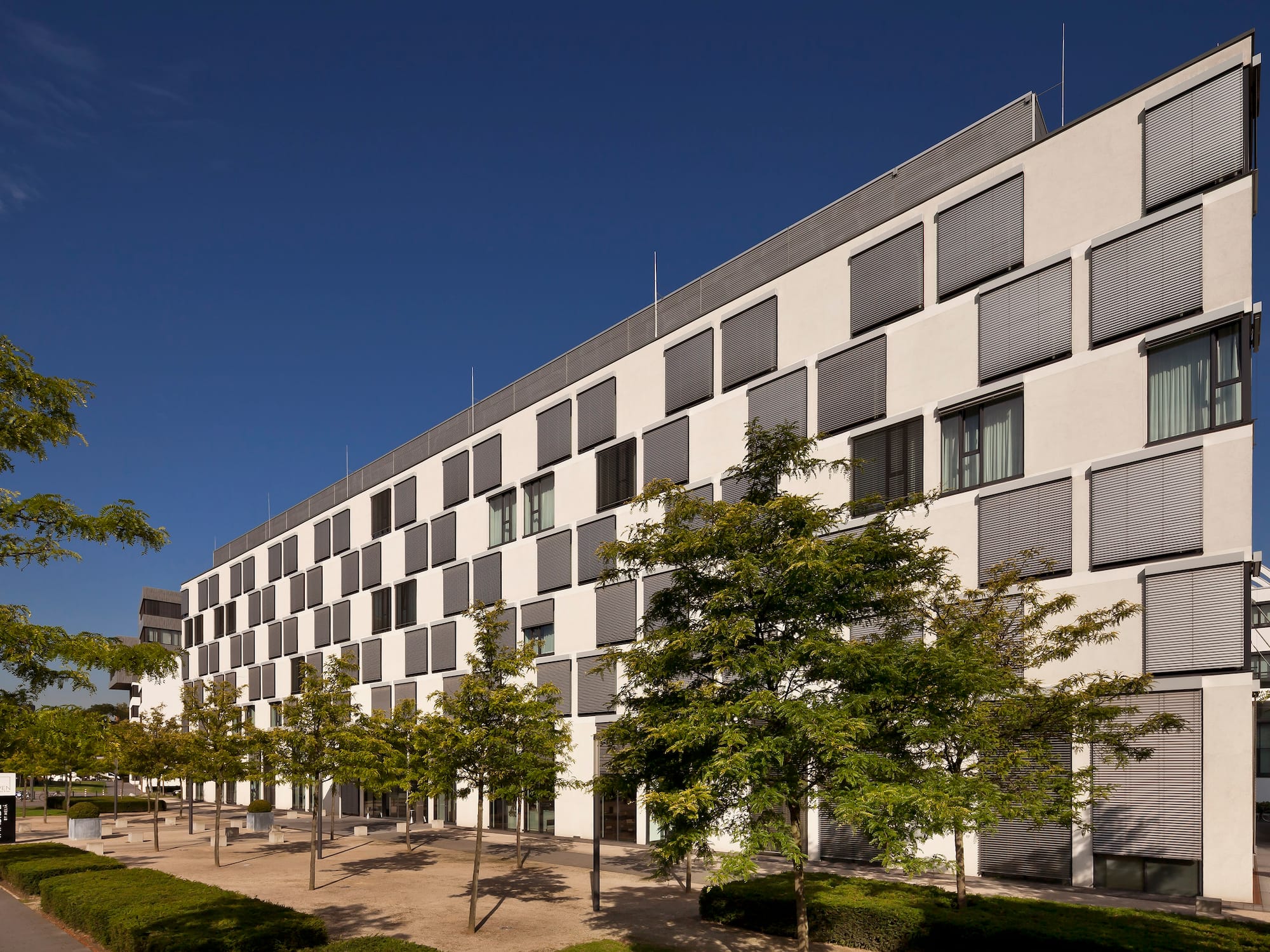Innside by Meliá hotel exterior: modern white building, many windows, green trees.